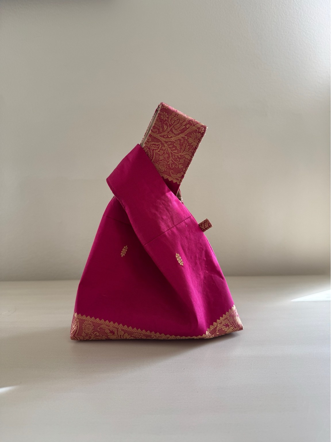 Actual pink Mina silk knot bag with gold woven borders
