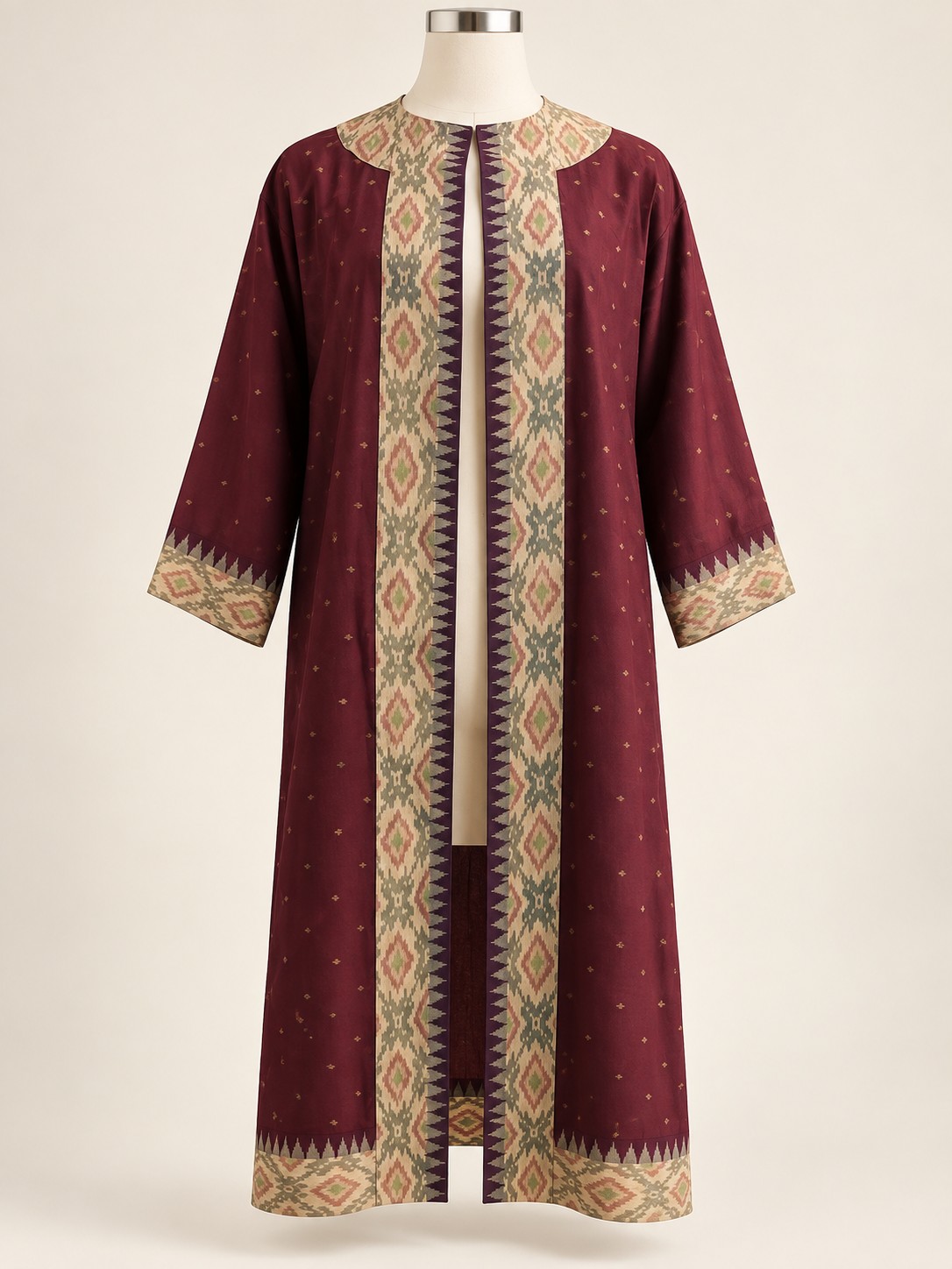 Retouched photograph of the maroon Amara jacket on a cream dress form